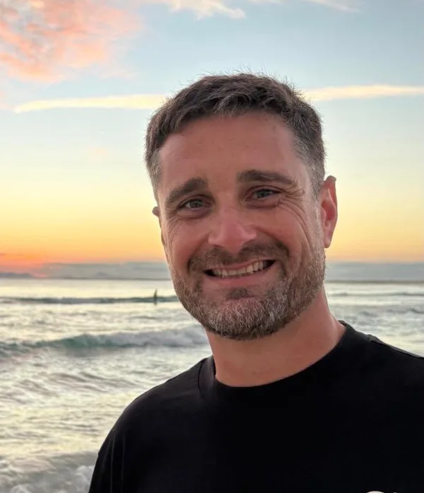 Martín Barletta sonriendo en la playa al atardecer